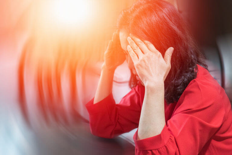 Woman holding her head and feeling dizzy