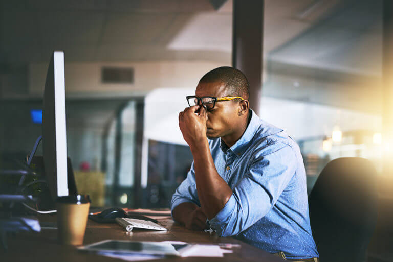 Man working at his desk with a headache