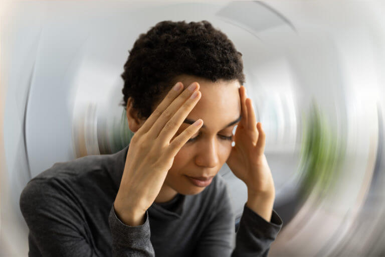 A young woman holding her head because she's dizzy