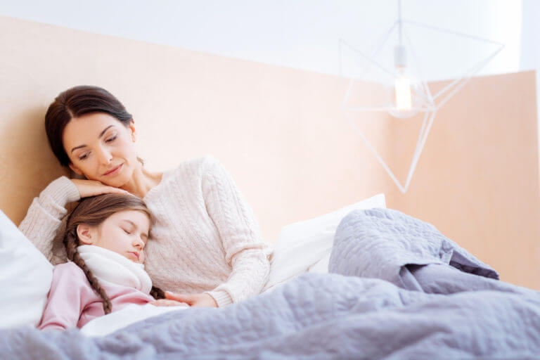 young girl experiencing a seizure and being comforted by her mom