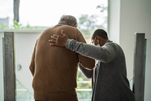 Home caregiver helping patient walking with Parkinson's disease