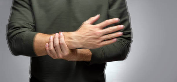 a man with a tremor tries to keep his hand from trembling with the help of the other.