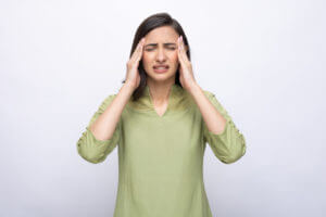 A picture depicting a young woman suffering from a severe headache.